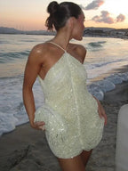 Robe courte asymétrique en tissu scintillant avec col licou, idéale pour les soirées cocktail et les occasions spéciales.