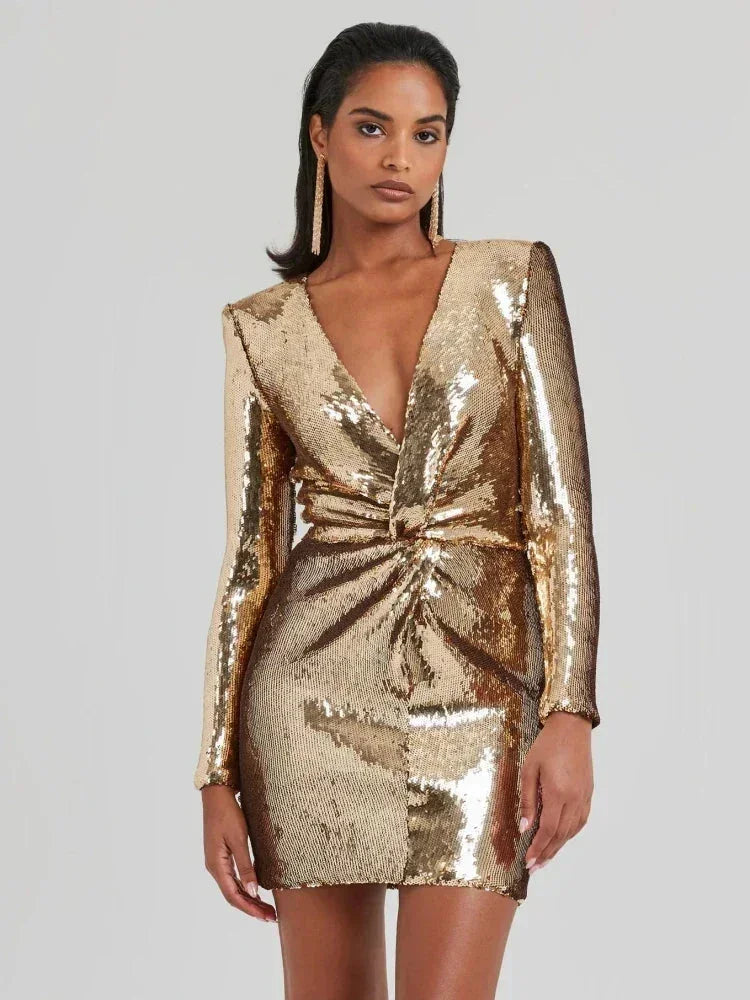 Robe courte en tissu brillant avec sequins dorés, manches longues et col en V drapé, parfaite pour une soirée clubbing.