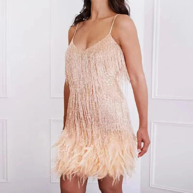 Robe courte en sequins avec plumes, à bretelles fines, idéale pour les soirées cocktail. Matière brillante et élégante.
