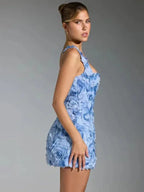 Robe courte à bretelles en tissu texturé avec motif floral, parfaite pour une soirée élégante.