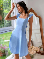 Robe courte évasée avec volants, bretelles ajustables, en tissu léger, idéale pour l'été, disponible en plusieurs couleurs.