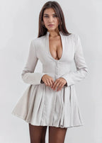 Robe courte évasée en tissu léger, cintrée avec décolleté plongeant et manches longues, parfaite pour une soirée élégante.