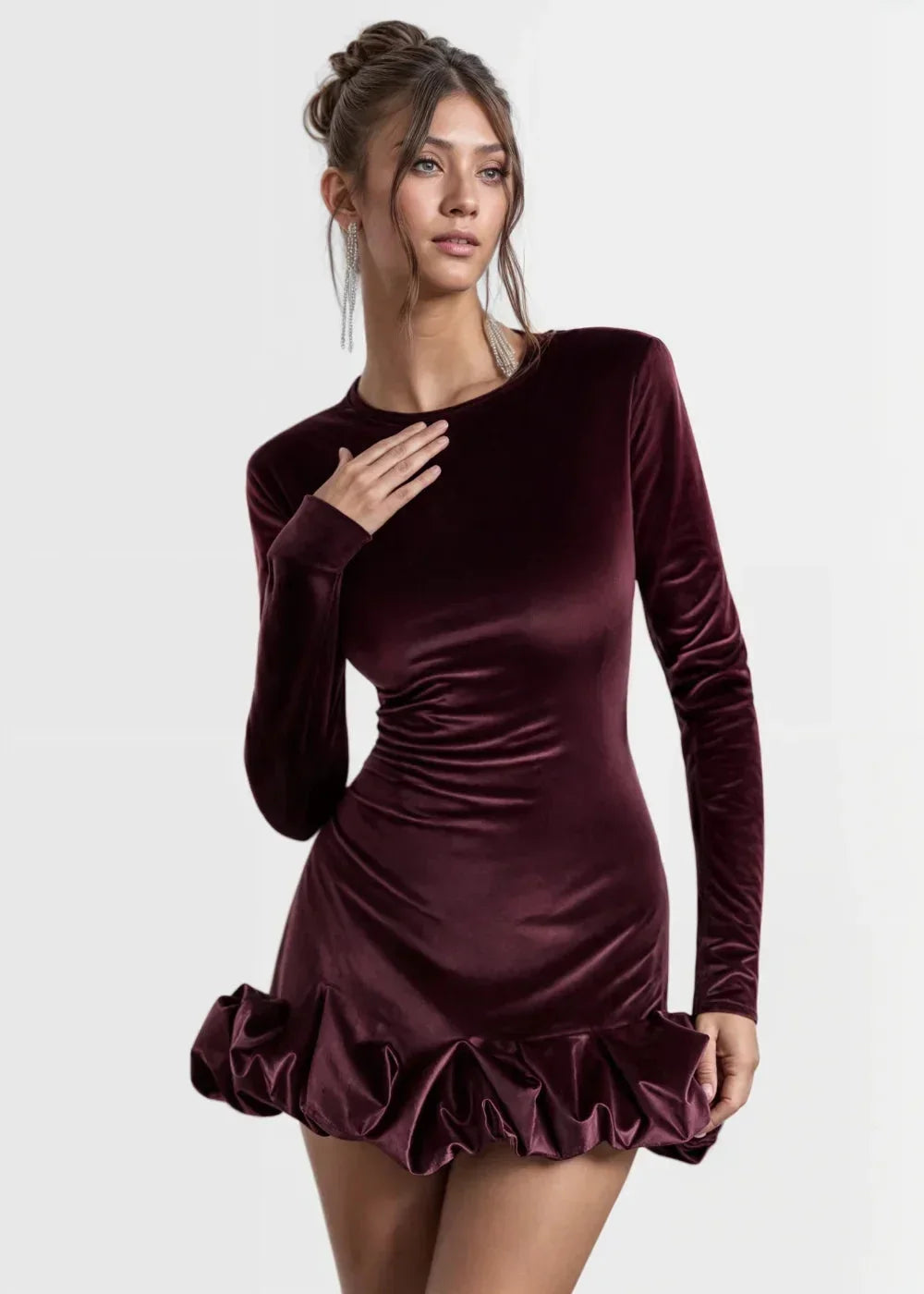Robe courte en velours bordeaux avec ourlet volant, manches longues et coupe ajustée pour soirées élégantes.