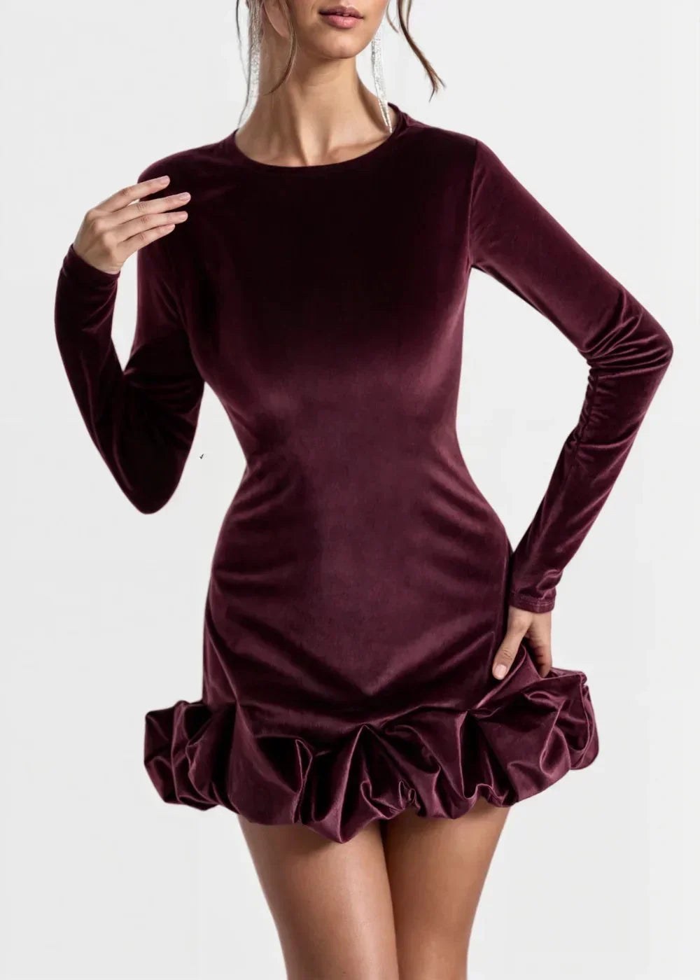Robe courte en velours bordeaux avec ourlet volant et manches longues, coupe ajustée pour une silhouette raffinée.
