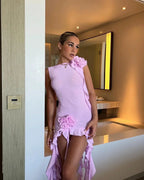 Robe courte violette sans manches avec volants et motifs floraux, idéale pour les soirées d'été, en tissu léger et respirant.