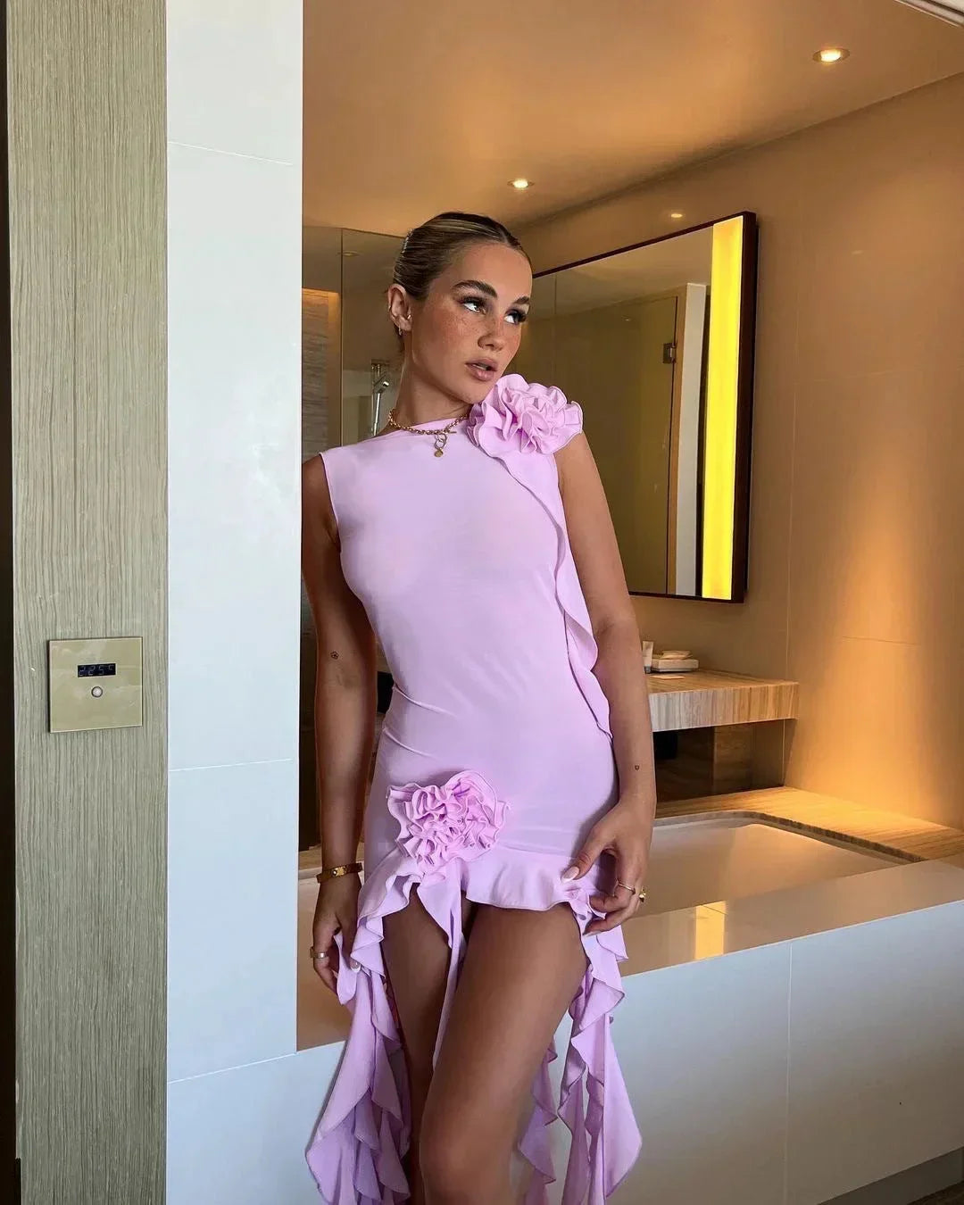 Robe courte violette sans manches avec volants et motifs floraux, idéale pour les soirées d'été, en tissu léger et respirant.