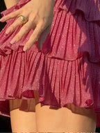 Robe courte rose à volants scintillants, détails étoiles, bretelles larges, parfaite pour soirée ou plage. Made in polyester.