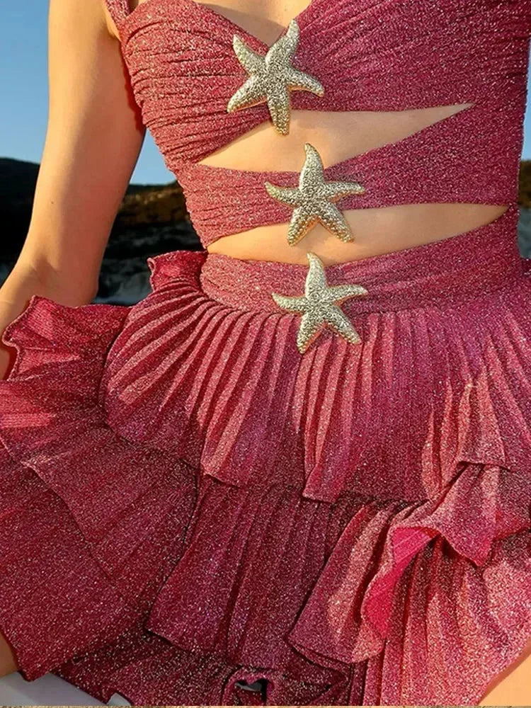 Robe courte rose à volants scintillants, détails étoiles, bretelles larges, idéale pour soirées d'été et plage.