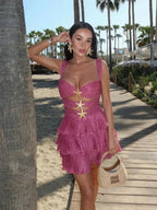 Robe courte rose à volants scintillants avec détails d'étoiles et bretelles larges, idéale pour des soirées d'été à la plage.