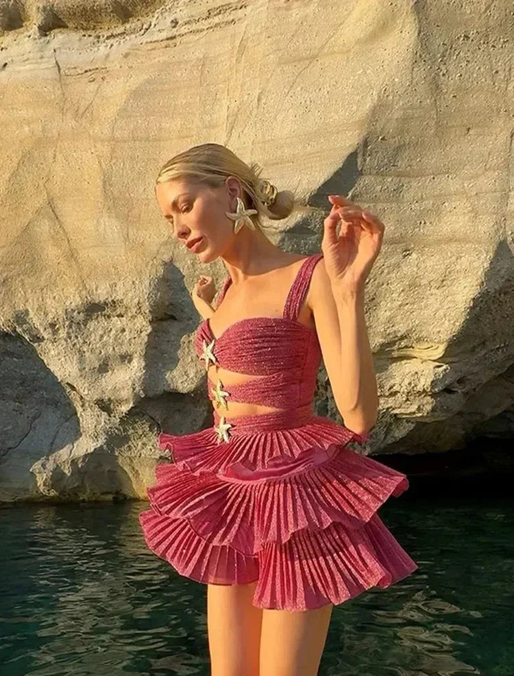 Robe courte rose à volants scintillants, détails étoiles, bretelles larges, idéale pour soirées ou journées à la plage.