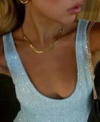 Robe ajustée sans manches en tissu scintillant, disponible en plusieurs couleurs pour des occasions festives.