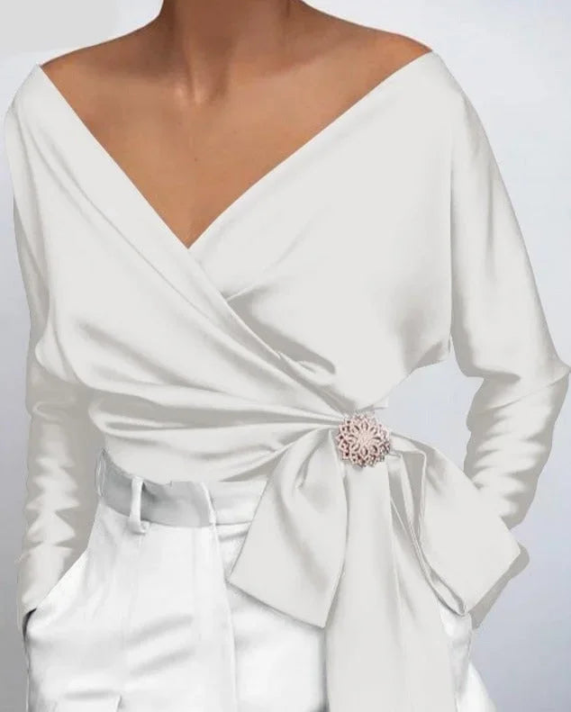 Top femme portefeuille rose avec nœud et broche, design élégant pour un usage quotidien ou occasions spéciales.