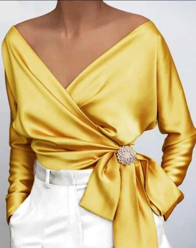 Top femme portefeuille argenté avec nœud et broche, en cuir, design pratique et élégant.