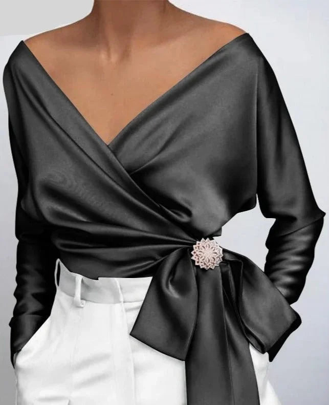 Top femme portefeuille rose avec nœud décoratif et broche, conçu pour un usage quotidien.