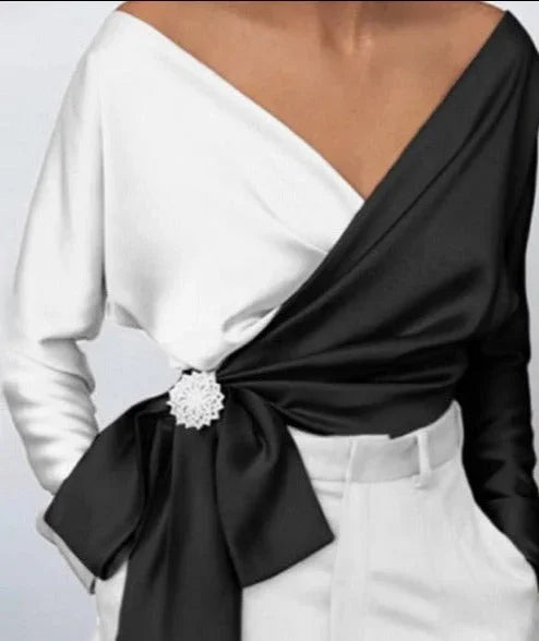 Top femme portefeuille rose avec nœud et broche, design élégant et intemporel.