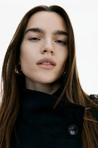 Trench-coat femme avec col montant et ceinture nouée, conçu en matériau résistant, adapté aux saisons intermédiaires.