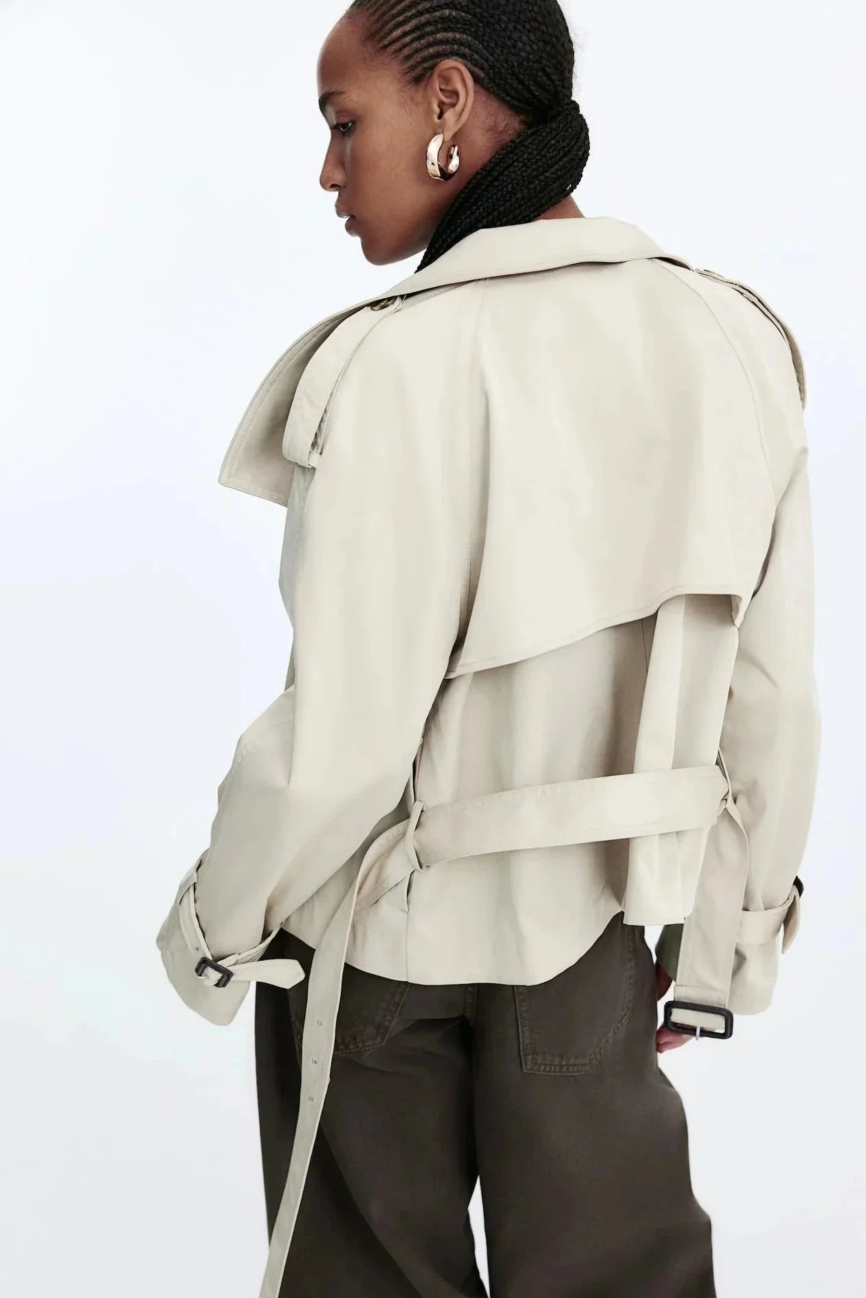 Trench-coat femme noir, col montant, ceinture nouée, coupe classique, tissu résistant et déperlant.