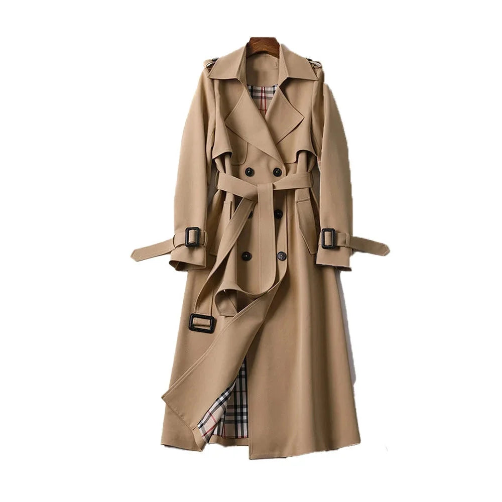 Trench-coat long beige pour femme, ceinturé, avec col à revers et en tissu résistant.