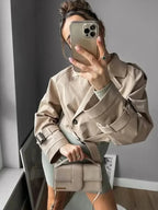 Trench court beige femme à manches longues, design classique avec détails élégants en tissu résistant.