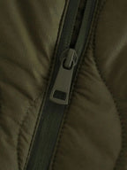 Veste ample matelassée femme vert olive avec poches latérales et fermeture éclair intégrale.