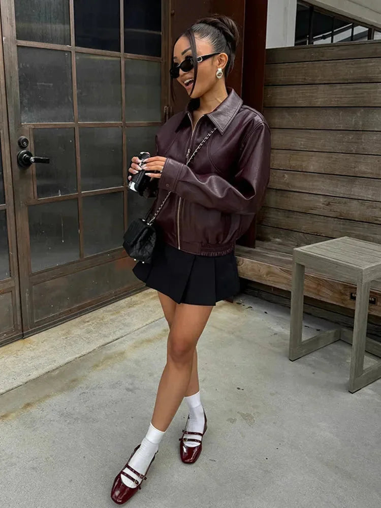 Veste bomber femme bordeaux en simili cuir avec détails minimalistes et coupe légère.