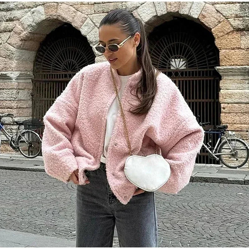 Veste bomber femme rose en matière teddy, avec coupe décontractée et bords élastiques.