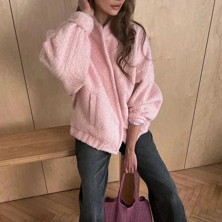 Veste bomber femme rose en matière teddy, coupe classique avec des bords élastiques.
