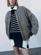 Veste bomber femme oversize matelassée noire avec boutons-pression, idéale pour des tenues décontractées.