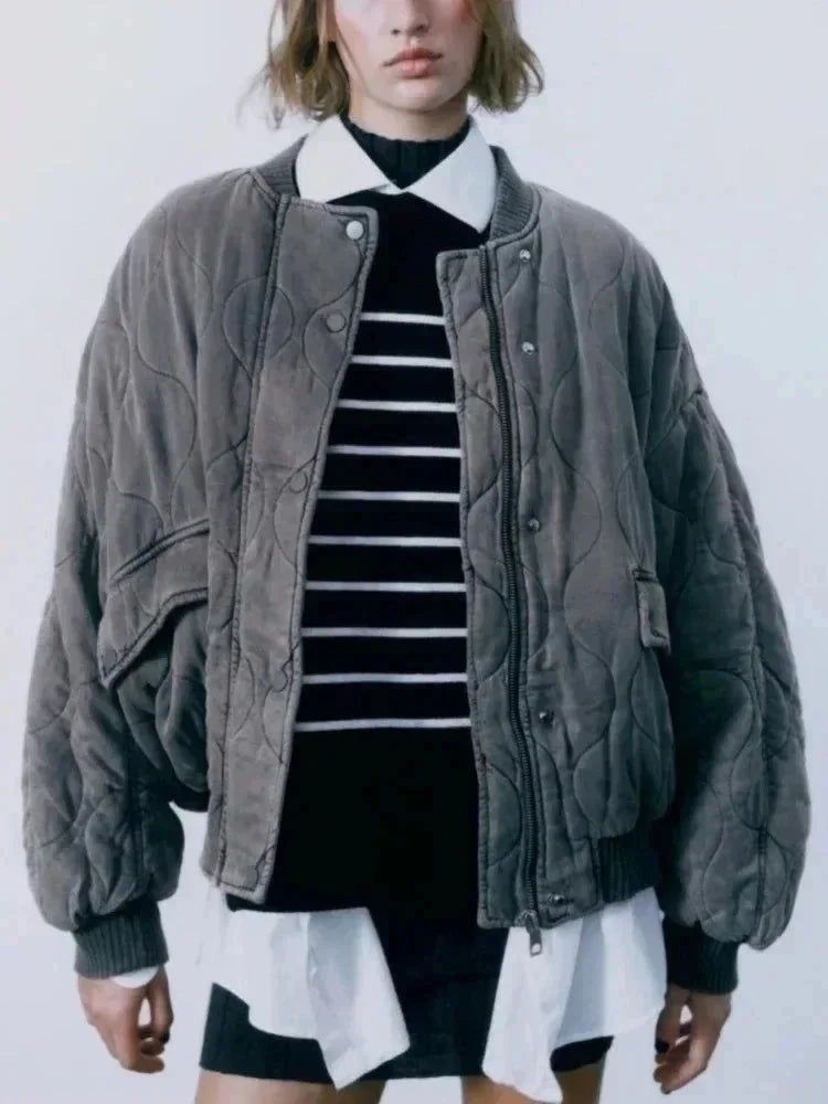 Oversize Damen Bomberjacke aus gestepptem Material mit Druckknöpfen in modischem Design.