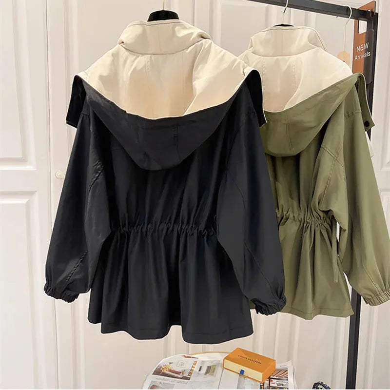 Veste coupe-vent noire pour femme, légère, avec capuche amovible et poches pratiques.