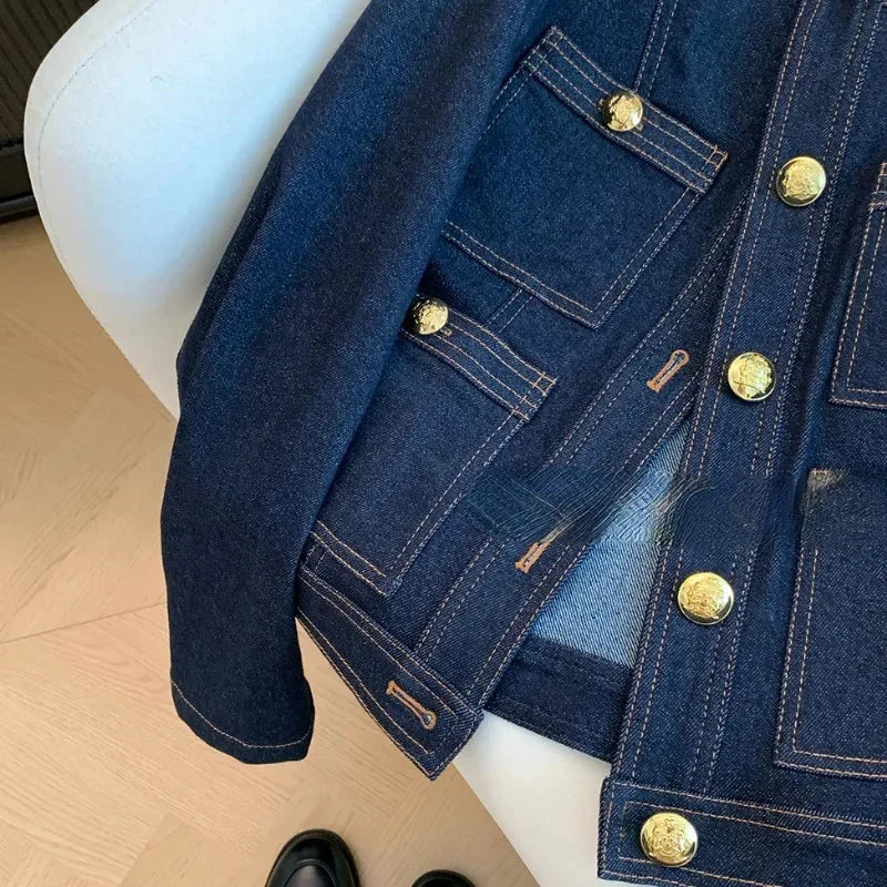 Veste en denim bleu foncé pour femme, avec boutons dorés, design classique et tissu résistant.