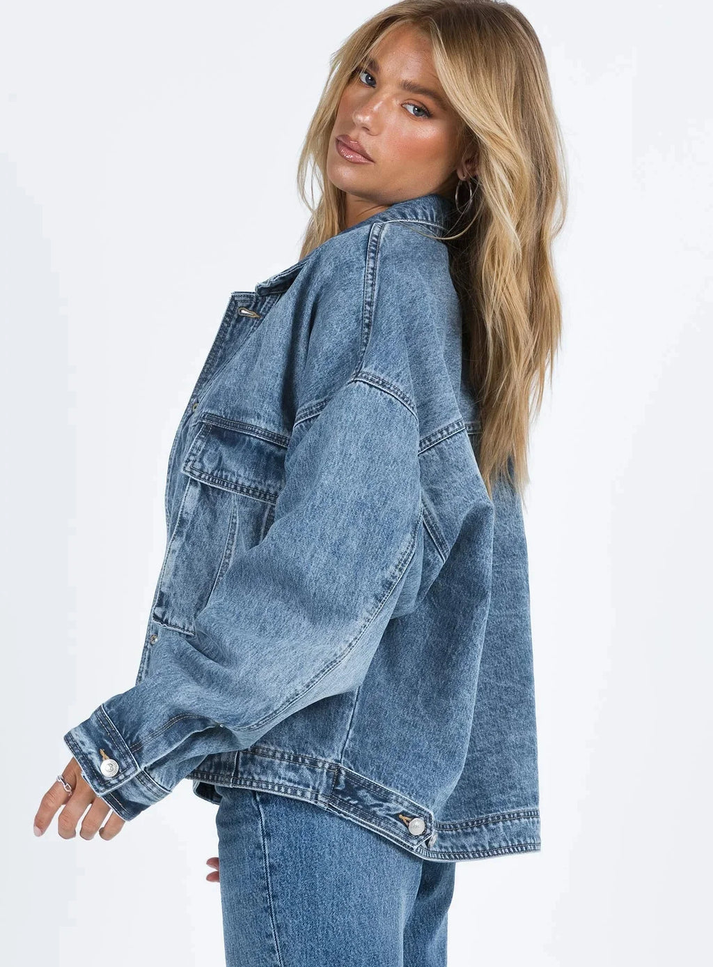 Veste en jean bleu pour femme, coupe ample, style rétro, en mélange de coton, avec poches classiques et fermeture à boutons.