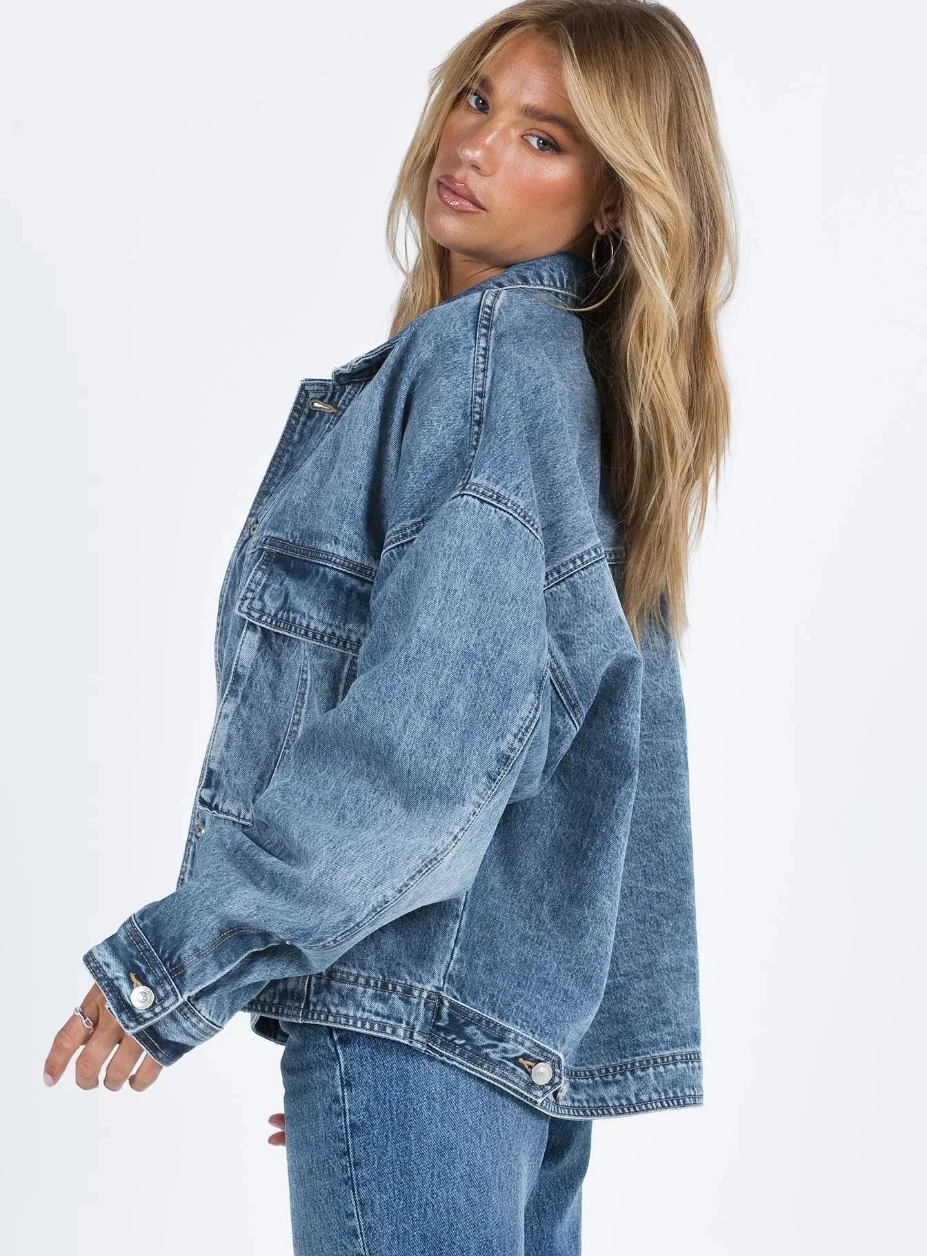 Veste en jean bleu pour femme, coupe ample, style rétro, en mélange de coton, avec poches classiques et fermeture à boutons.