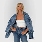 Veste en jean bleu pour femme, coupe ample, détails de boutons rétro et deux poches poitrine.