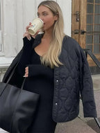 Veste femme ample matelassée noire, légère et chaude, avec poches pratiques pour l'hiver.