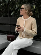 Veste femme beige courte en tweed avec boutons, adaptée pour des tenues décontractées et élégantes.