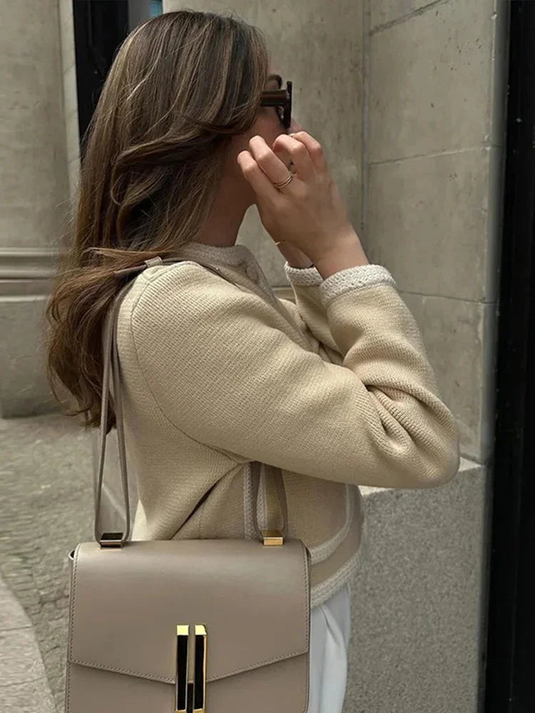 Veste courte beige en tweed pour femme, avec boutons classiques et design structuré.