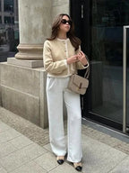 Veste courte en tweed beige pour femme avec boutons décoratifs et coupe classique.