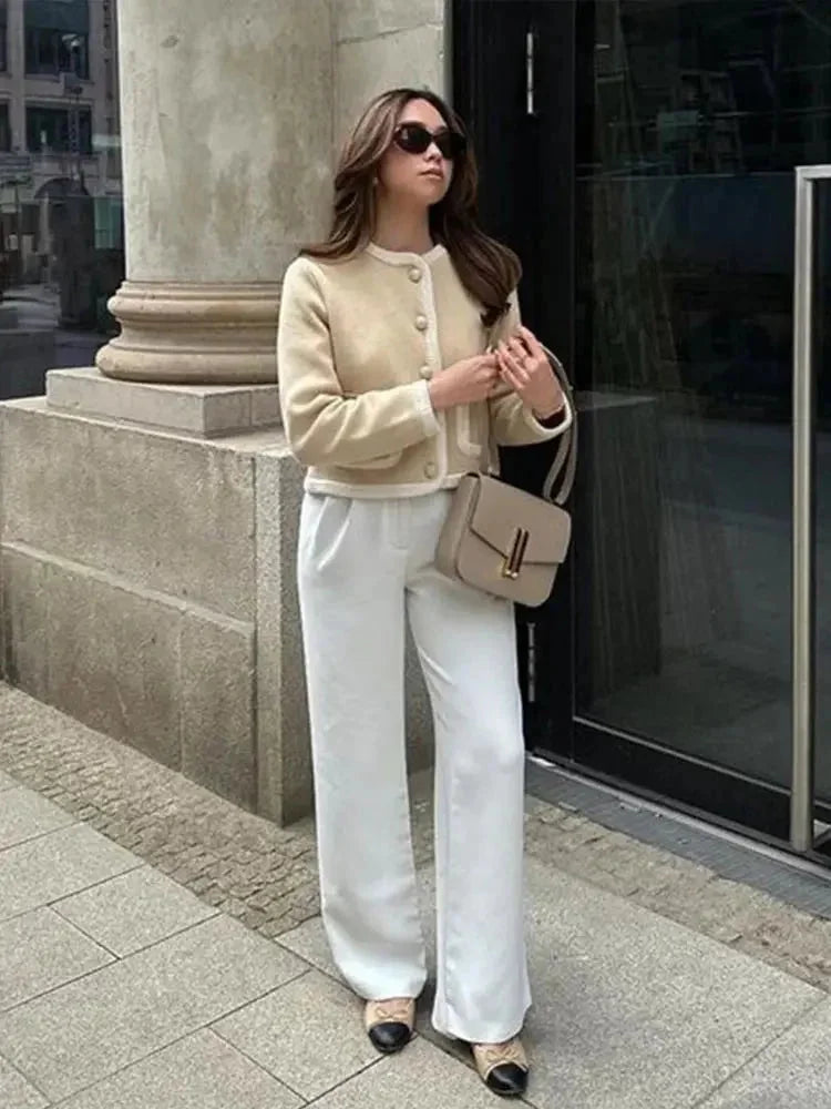 Veste courte en tweed beige pour femme avec boutons décoratifs et coupe classique.