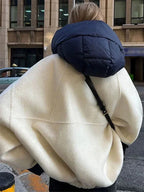 Veste femme à capuche blanche, rembourrée, en matériau résistant, avec poches latérales pratiques.