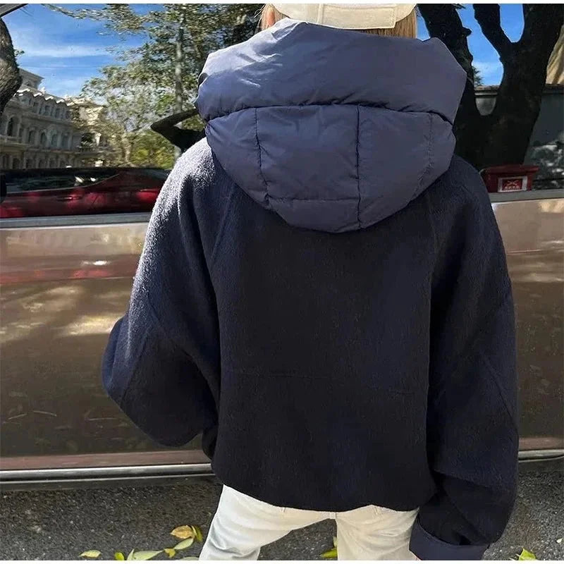 Veste femme à capuche bleu marine, rembourrage épais, design sportif et poches latérales pratiques.