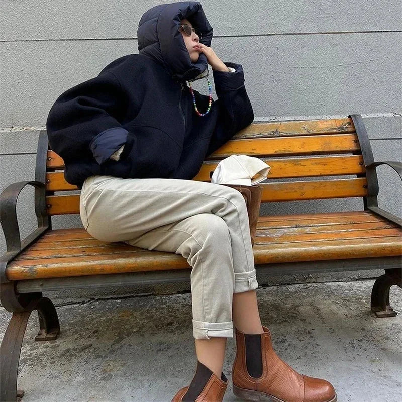 Veste femme à capuche bleu marine, rembourrée, en matériau résistant, conçue pour les journées fraîches.