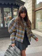 Veste femme à carreaux grise, manches bouffantes, en tissu léger, coupe classique pour des looks variés.