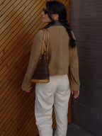 Veste femme marron en polyester, col contrastant, poches avant et coupe élégante.