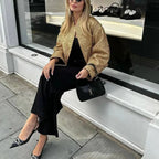 Veste femme chic à paillettes, en tissu doux, avec une coupe ajustée et des embellissements scintillants sur les manches.