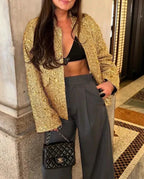 Veste femme noire à paillettes, coupe ajustée et tissu doux, adaptée pour des occasions spéciales.