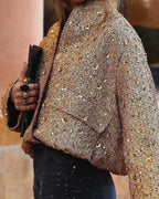 Veste femme dorée à paillettes, coupe élégante, manches longues, adaptée pour des occasions festives.