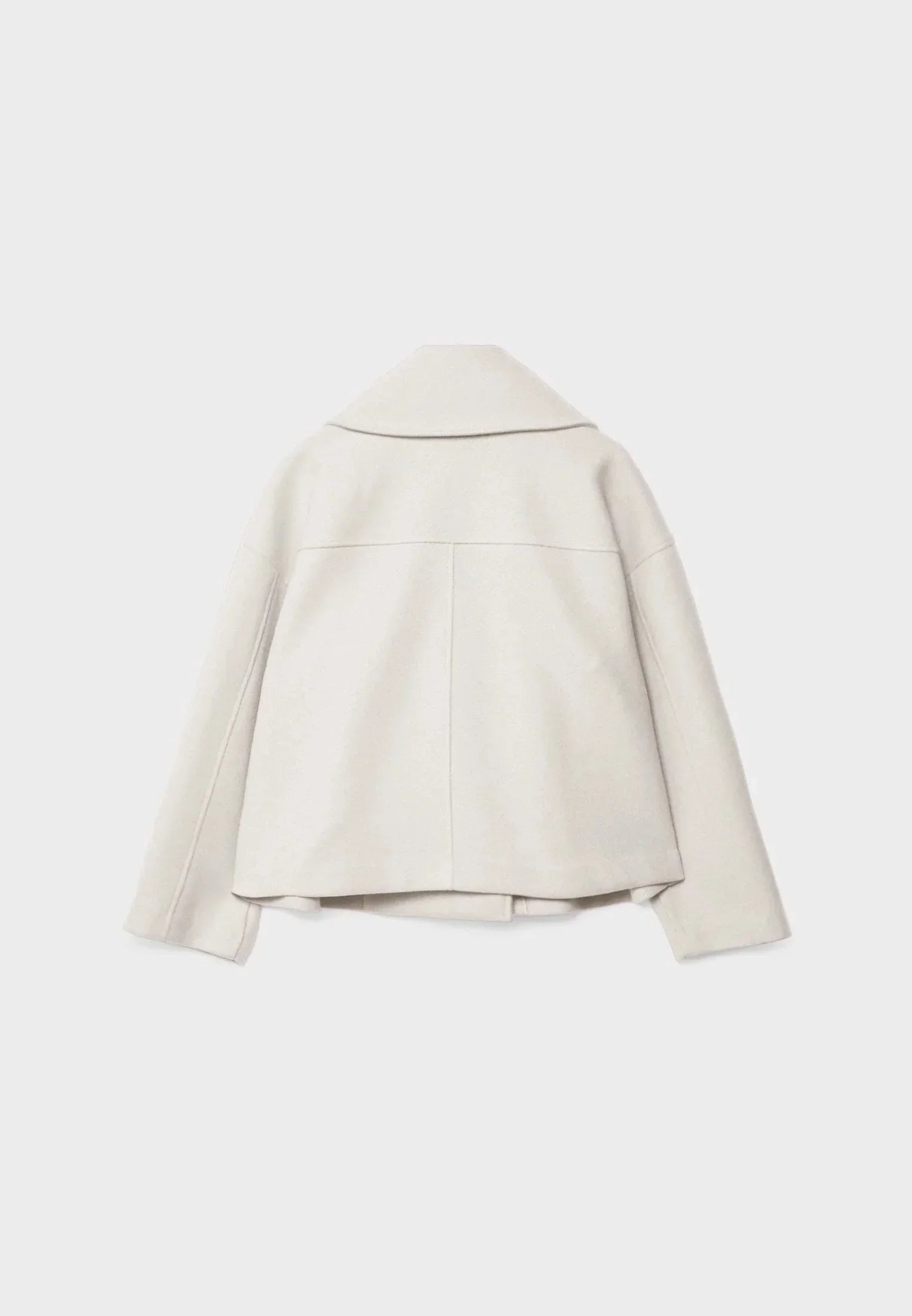 Veste femme courte beige à double boutonnage, en tissu doux et respirant, au design classique.