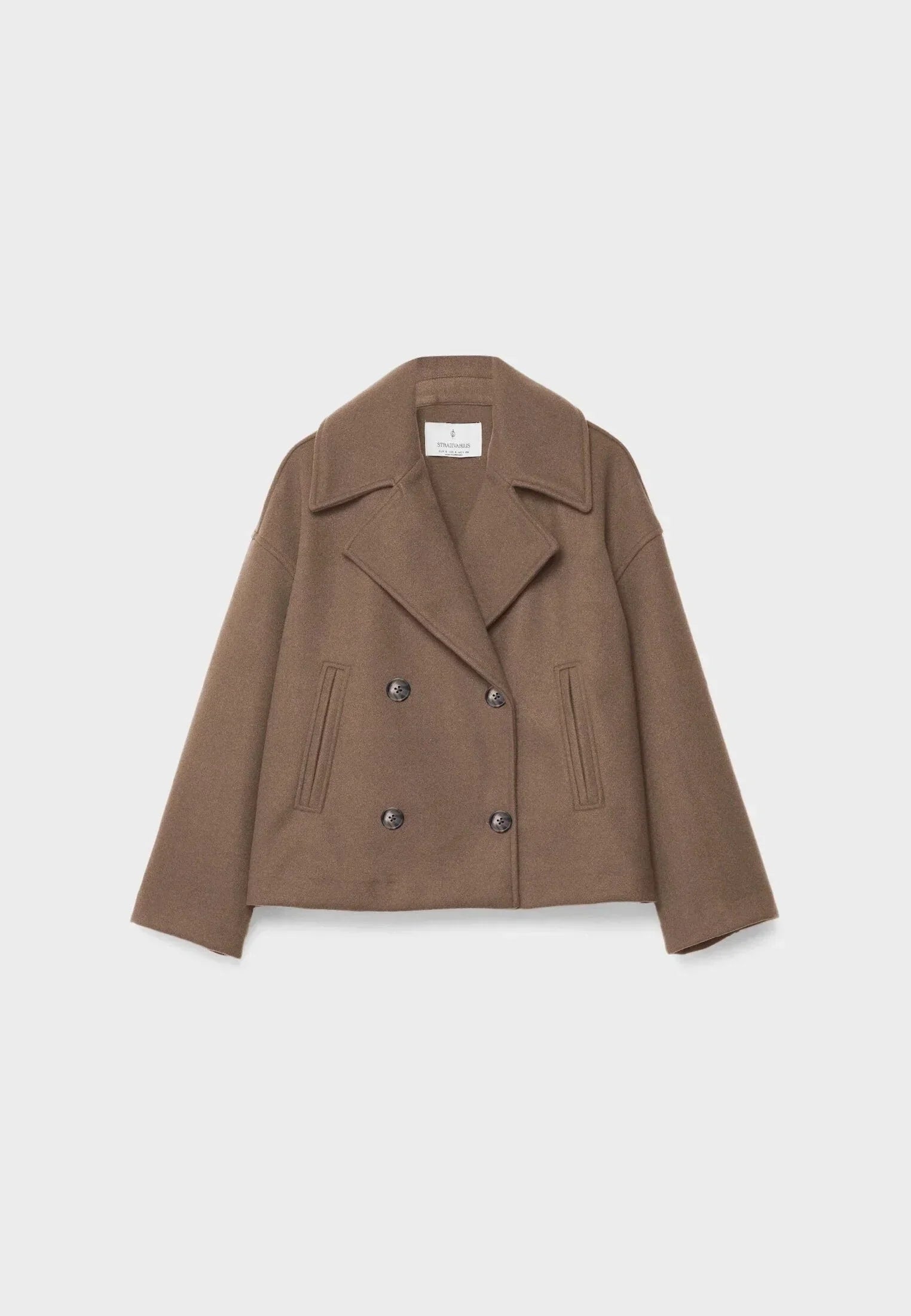 Veste femme courte beige à double boutonnage, design moderne avec deux rangées de boutons.
