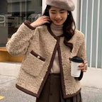 Veste femme courte en tissu peluche beige avec coutures élégantes et fermeture éclair. Parfaite pour les journées fraîches.